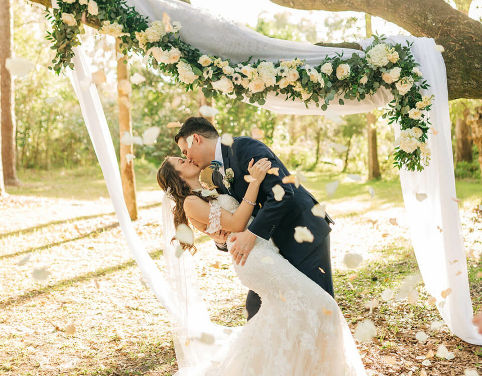 Bride And Groom Kiss Under Floral Arch