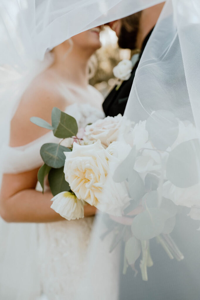 Bride Holding Flowers Under Veil